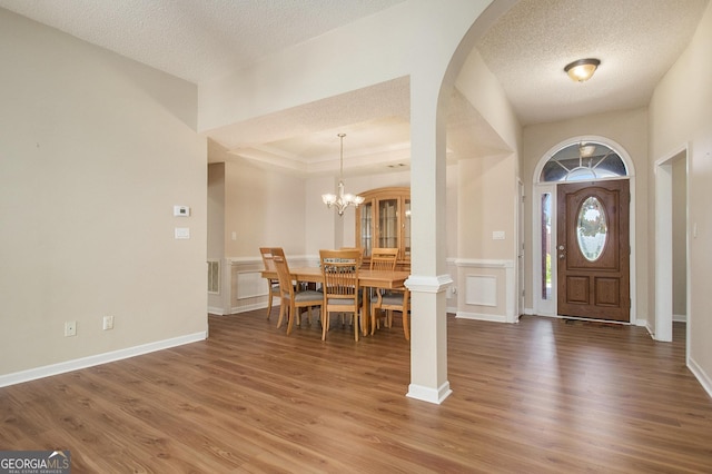 286 Prominent Loop, Mcdonough, GA 30253 - foyer entrance with wood finished floors, a textured ceiling, arched walkways, a chandelier, and a decorative wall