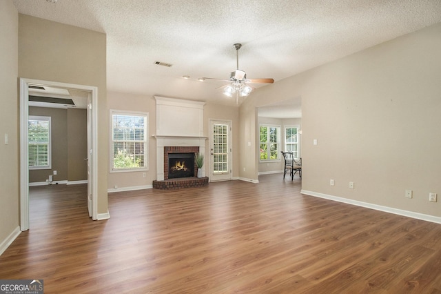 286 Prominent Loop, Mcdonough, GA 30253 - unfurnished living room featuring ceiling fan, wood finished floors, a fireplace, a textured ceiling, and vaulted ceiling