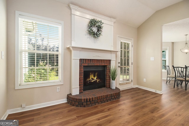 286 Prominent Loop, Mcdonough, GA 30253 - living area with wood finished floors, a brick fireplace, and vaulted ceiling