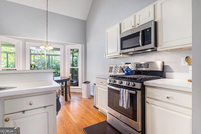 1469 Crescent Walk, Decatur, GA 30033 - kitchen featuring appliances with stainless steel finishes, vaulted ceiling, light countertops, light wood-style flooring, and hanging light fixtures