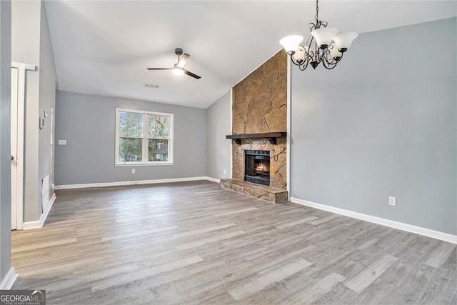 3918 S Creek Ct, Stone Mountain, GA 30083 - unfurnished living room featuring lofted ceiling, wood finished floors, a ceiling fan, a chandelier, and a stone fireplace