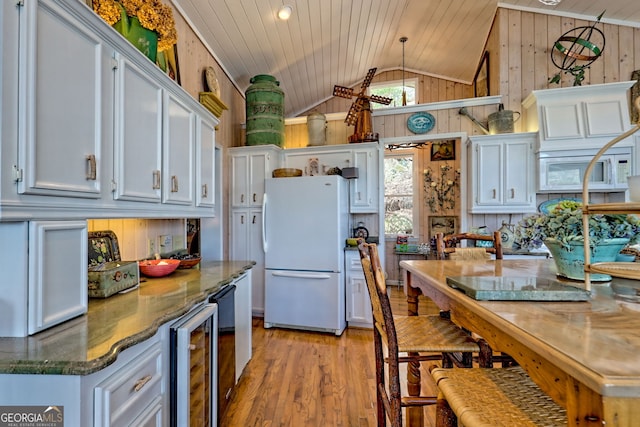165 Pepe Rd, Clayton, GA 30525 - kitchen featuring white appliances, wooden walls, beverage cooler, light wood finished floors, and vaulted ceiling