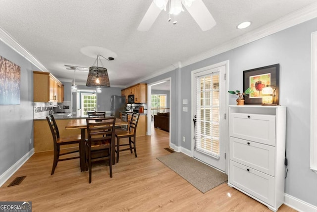15 Miners Pt SE, Acworth, GA 30102 - dining area with crown molding, light wood-style flooring, a ceiling fan, and a textured ceiling