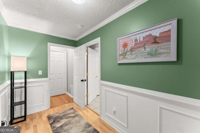 15 Miners Pt SE, Acworth, GA 30102 - corridor featuring a textured ceiling, a wainscoted wall, ornamental molding, and light wood-style flooring