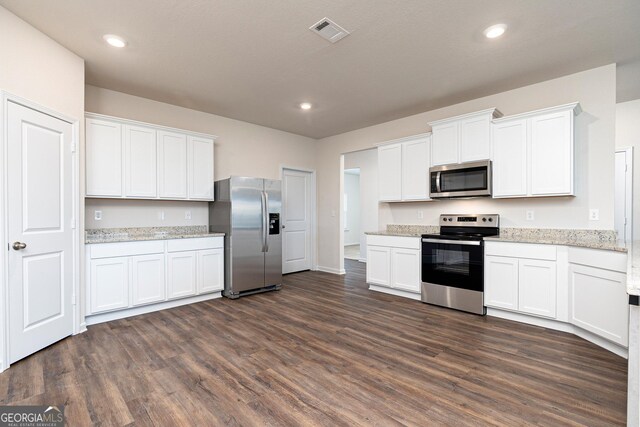 1512 Big Bud Ln, Locust Grove, GA 30248 - kitchen with stainless steel appliances, dark wood finished floors, white cabinets, light stone counters, and recessed lighting