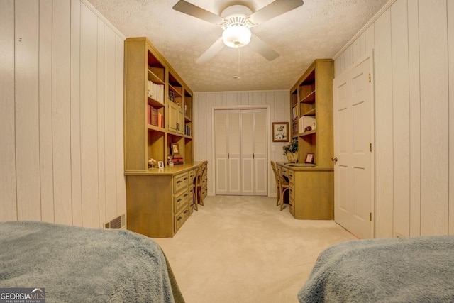 2400 White Pine Ln, Mansfield, GA 30055 - bedroom featuring a textured ceiling, light carpet, wood walls, a ceiling fan, and a closet
