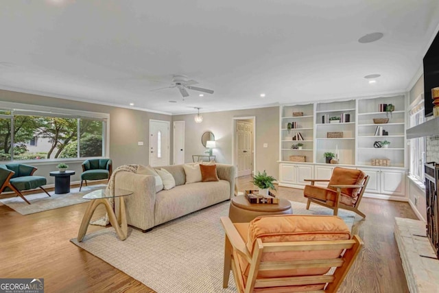 1693 Alderbrook Rd NE, Atlanta, GA 30345 - living room featuring ceiling fan, wood finished floors, a fireplace with raised hearth, crown molding, and recessed lighting