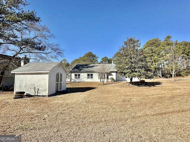 4035 Winchester Way, Loganville, GA 30052 - rear view of property featuring a storage unit, a chimney, and a yard