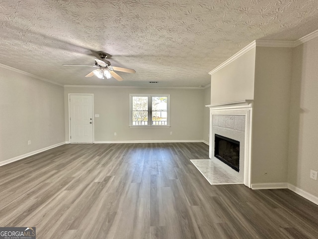 4035 Winchester Way, Loganville, GA 30052 - unfurnished living room with dark wood-style floors, ceiling fan, a fireplace with flush hearth, crown molding, and a textured ceiling