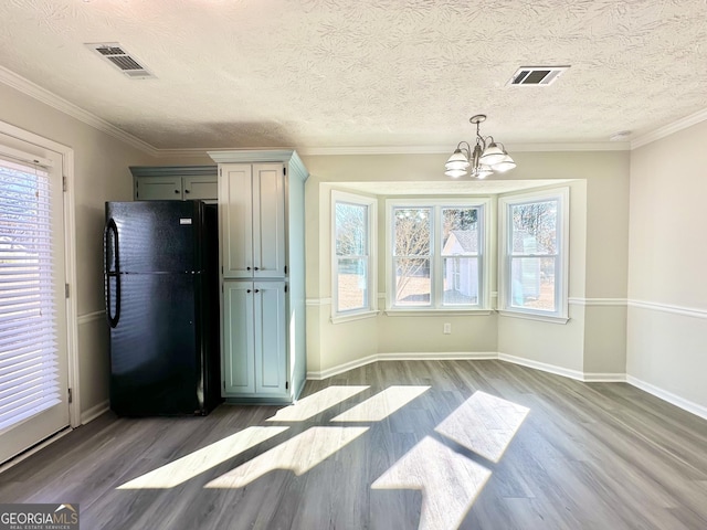 4035 Winchester Way, Loganville, GA 30052 - unfurnished dining area featuring a chandelier, wood finished floors, healthy amount of natural light, and a textured ceiling
