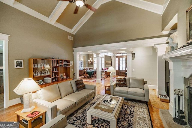2052 Trimleston Rd, Statham, GA 30666 - living area featuring ceiling fan, ornate columns, high vaulted ceiling, a fireplace, and light wood-style floors