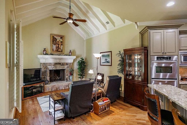 2052 Trimleston Rd, Statham, GA 30666 - living room with a ceiling fan, vaulted ceiling, a fireplace, light wood-style flooring, and crown molding