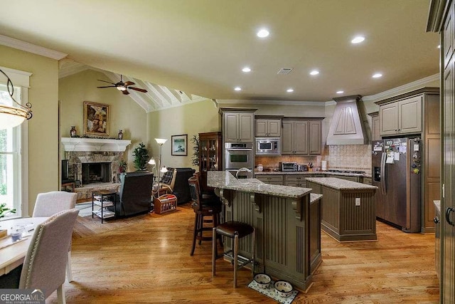 2052 Trimleston Rd, Statham, GA 30666 - kitchen featuring appliances with stainless steel finishes, a kitchen island with sink, crown molding, premium range hood, and ceiling fan