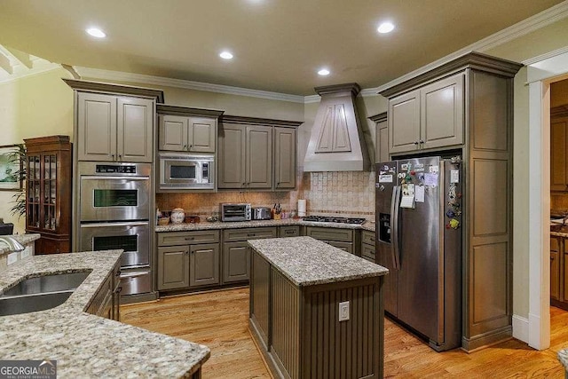 2052 Trimleston Rd, Statham, GA 30666 - kitchen featuring appliances with stainless steel finishes, custom exhaust hood, a center island, gray cabinetry, and decorative backsplash
