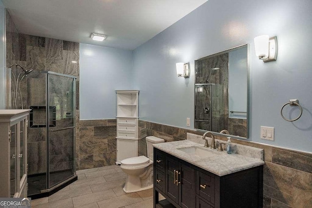 2052 Trimleston Rd, Statham, GA 30666 - bathroom featuring tile walls, a stall shower, vanity, tile patterned floors, and wainscoting