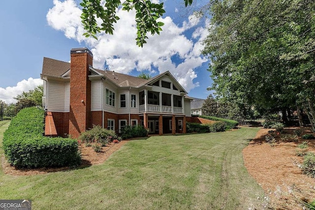 2052 Trimleston Rd, Statham, GA 30666 - back of house with a chimney, brick siding, a lawn, and a sunroom