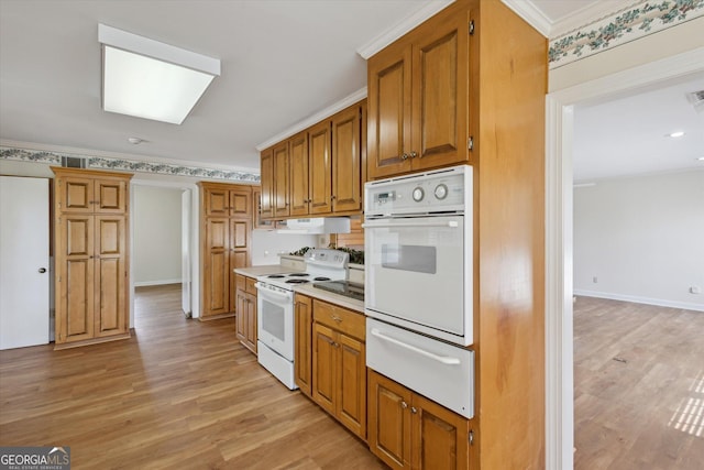 788 Buie Cir, Pembroke, GA 31321 - kitchen featuring white appliances, a warming drawer, light wood-style flooring, crown molding, and brown cabinetry