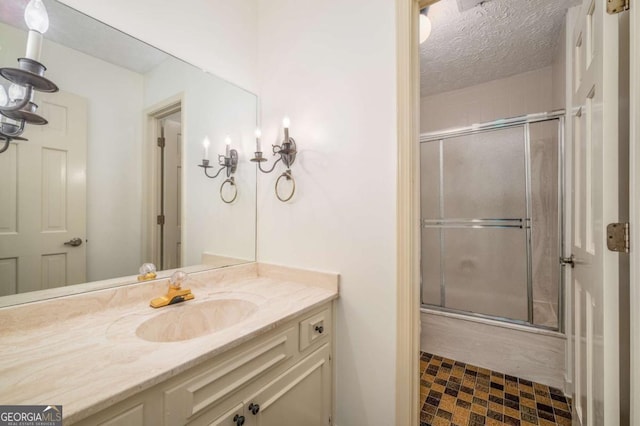 1690 Trotters Ln, Stone Mountain, GA 30087 - bathroom featuring vanity, bath / shower combo with glass door, and a textured ceiling