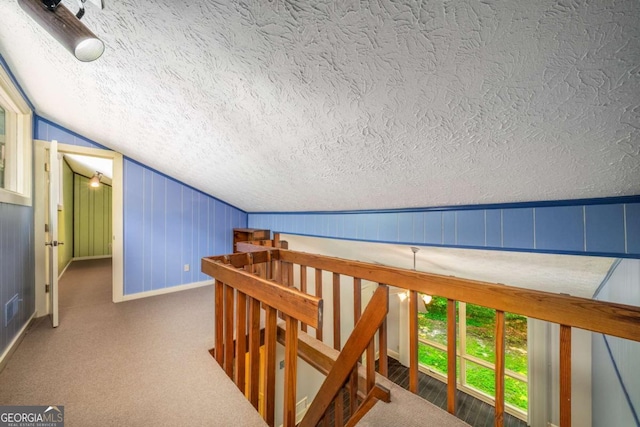1690 Trotters Ln, Stone Mountain, GA 30087 - corridor with an upstairs landing, a textured ceiling, vaulted ceiling, and carpet flooring