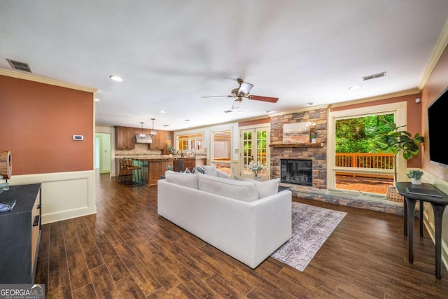 1690 Trotters Ln, Stone Mountain, GA 30087 - living room with crown molding, ceiling fan, a fireplace, dark wood-type flooring, and recessed lighting