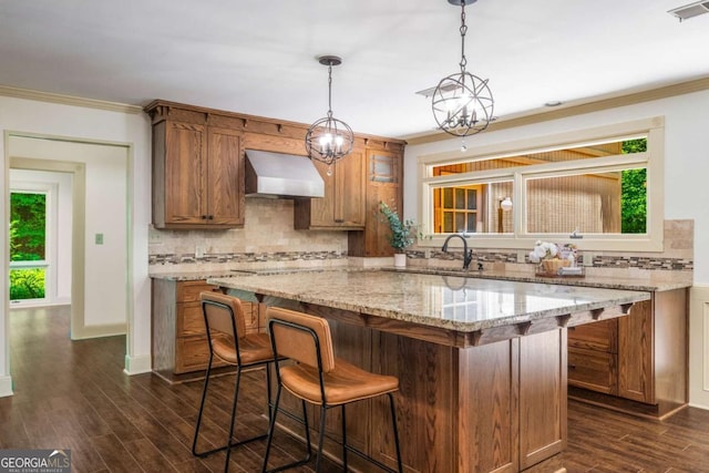 1690 Trotters Ln, Stone Mountain, GA 30087 - kitchen featuring tasteful backsplash, custom exhaust hood, a kitchen breakfast bar, dark wood finished floors, and ornamental molding