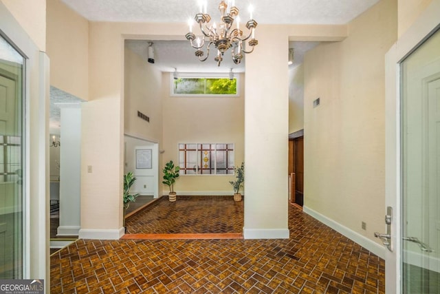 1690 Trotters Ln, Stone Mountain, GA 30087 - foyer entrance featuring brick patterned floors, a chandelier, and a high ceiling