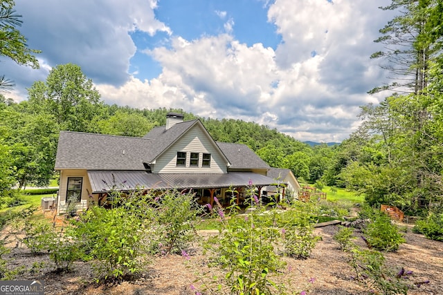 533 Ledford Rd, Dillard, GA 30537 - back of property featuring a chimney, a metal roof, roof with shingles, and a wooded view