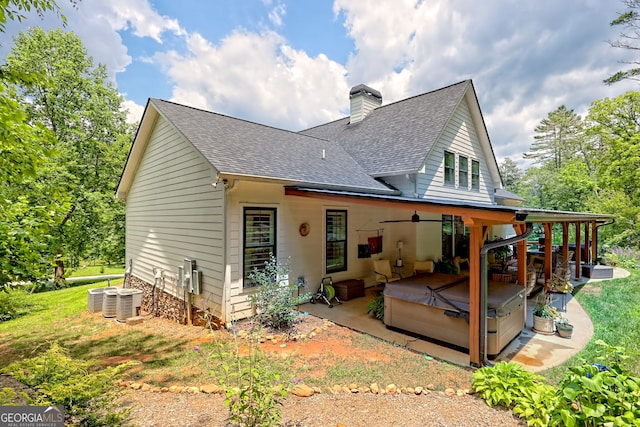 533 Ledford Rd, Dillard, GA 30537 - back of property featuring a hot tub, a patio area, roof with shingles, and a chimney