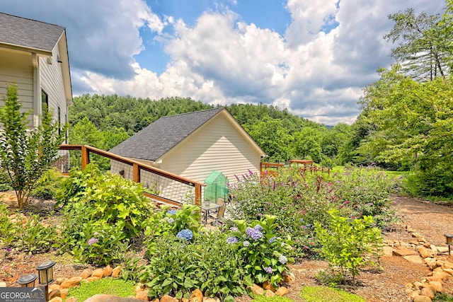 533 Ledford Rd, Dillard, GA 30537 - view of side of property featuring roof with shingles, a wooded view, and a deck