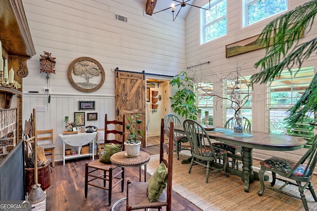 533 Ledford Rd, Dillard, GA 30537 - dining room with a towering ceiling, a barn door, dark wood-style flooring, wood walls, and a chandelier