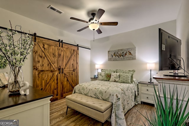 533 Ledford Rd, Dillard, GA 30537 - bedroom with wood finished floors, a barn door, and a ceiling fan