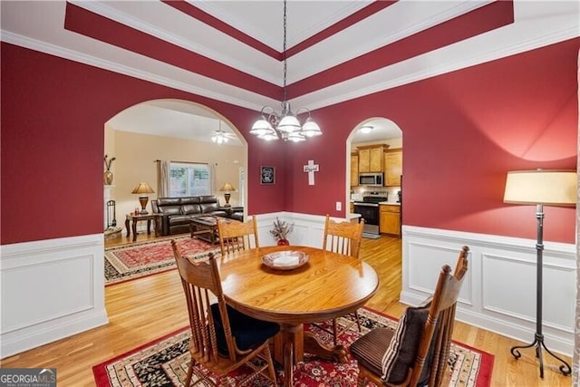 845 Darby Rd, Waleska, GA 30183 - dining space featuring arched walkways, a raised ceiling, light wood-style floors, wainscoting, and ornamental molding