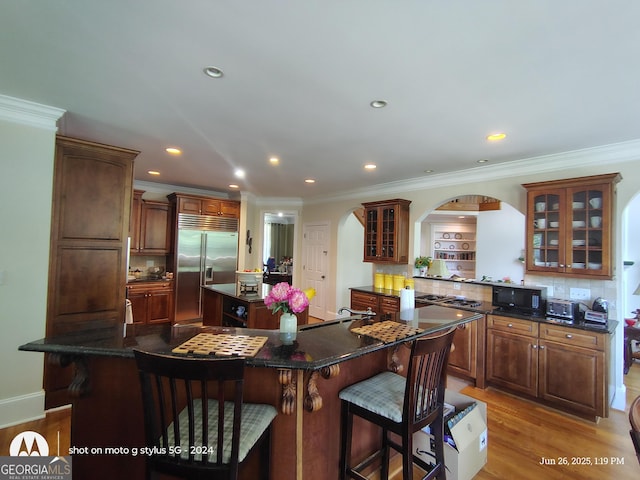 1292 Hidden Spirit Trl, Lawrenceville, GA 30045 - kitchen with stainless steel appliances, a center island, arched walkways, a breakfast bar, and backsplash