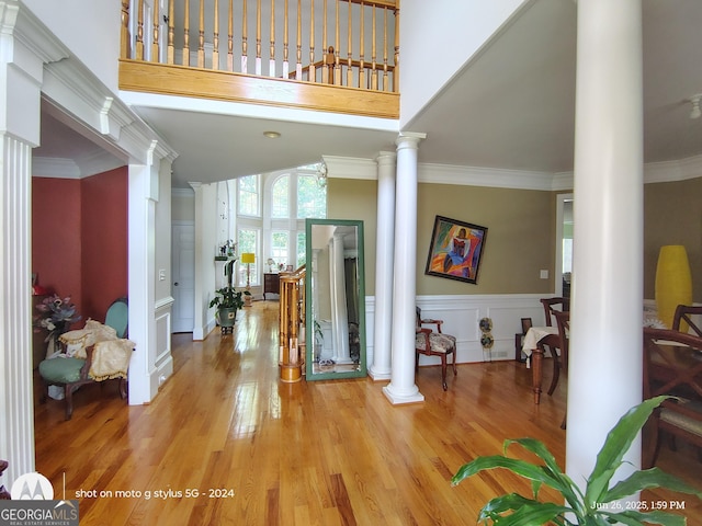 1292 Hidden Spirit Trl, Lawrenceville, GA 30045 - entryway with ornate columns, light wood-type flooring, wainscoting, crown molding, and a high ceiling