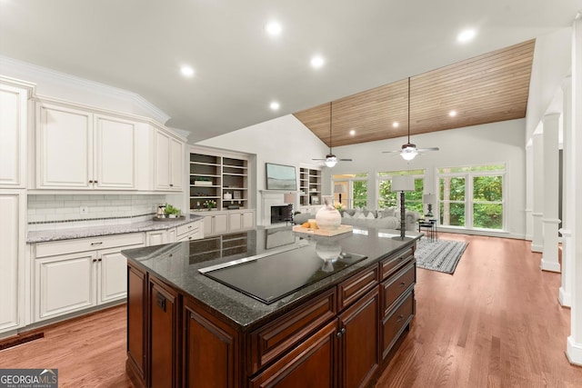 5455 Malone Ct, Powder Springs, GA 30127 - kitchen featuring black electric cooktop, open floor plan, white cabinetry, a fireplace, and a ceiling fan