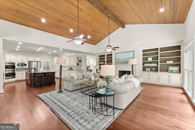 5455 Malone Ct, Powder Springs, GA 30127 - living room with a ceiling fan, a fireplace, built in shelves, a wood ceiling with exposed beams, and wood finished floors