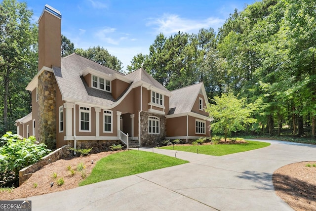 5455 Malone Ct, Powder Springs, GA 30127 - view of front of property featuring stone siding, a chimney, a front yard, driveway, and a shingled roof