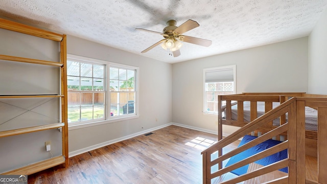 1437 18th St, Columbus, GA 31901 - unfurnished bedroom with a textured ceiling, wood finished floors, and a ceiling fan