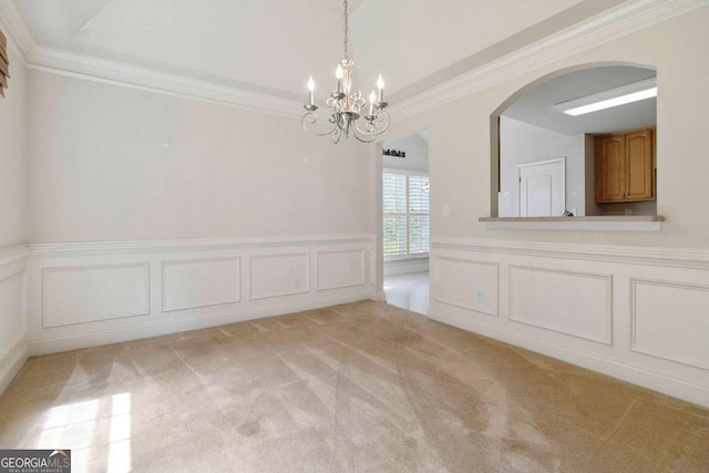 154 Ashebrooke Way, Jefferson, GA 30549 - unfurnished dining area with a chandelier, light colored carpet, ornamental molding, arched walkways, and a wainscoted wall