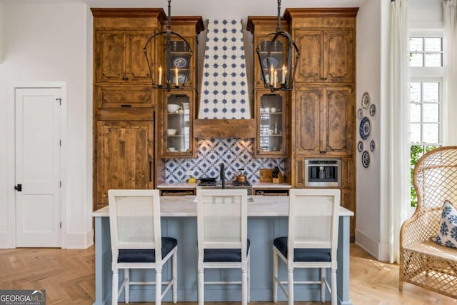 11277 Serenbe Ln, Chattahoochee Hills, GA 30268 - kitchen with light countertops, decorative backsplash, healthy amount of natural light, and a center island