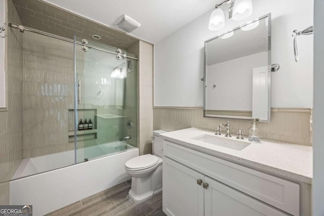 11277 Serenbe Ln, Chattahoochee Hills, GA 30268 - bathroom with vanity, shower / bath combination with glass door, wood tiled floors, and wainscoting