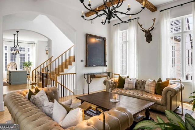 11277 Serenbe Ln, Chattahoochee Hills, GA 30268 - living area with a chandelier, arched walkways, stairs, and wood finished floors