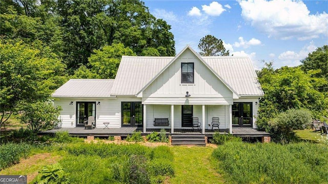 10975 Hutcheson Ferry Rd, Chattahoochee Hills, GA 30268 - modern farmhouse style home featuring board and batten siding, a metal roof, and french doors
