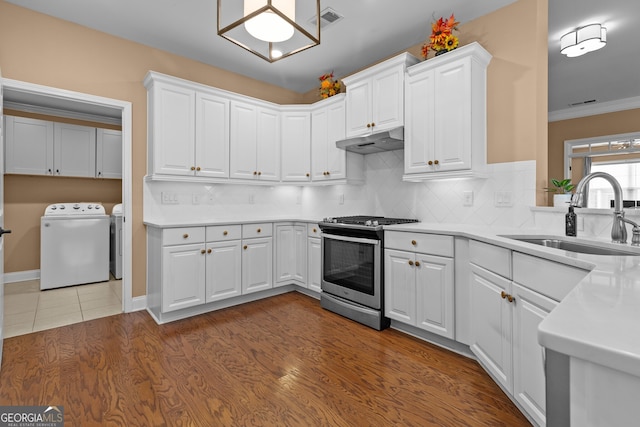 3209 Telhurst Way, Buford, GA 30519 - kitchen featuring stainless steel gas range, washer and clothes dryer, under cabinet range hood, light countertops, and white cabinetry