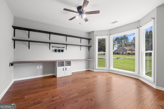 1501 Cayla Way, Statesboro, GA 30458 - unfurnished living room with built in study area, healthy amount of natural light, wood finished floors, and a ceiling fan