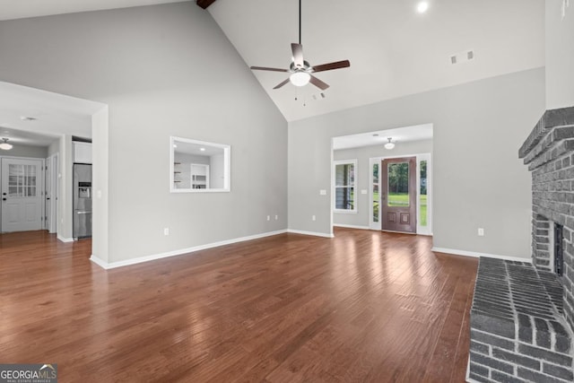 1501 Cayla Way, Statesboro, GA 30458 - unfurnished living room with high vaulted ceiling, ceiling fan, a brick fireplace, and wood finished floors