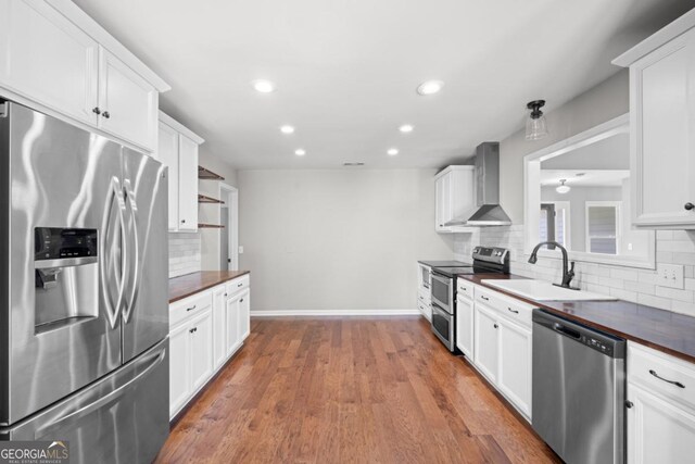 1501 Cayla Way, Statesboro, GA 30458 - kitchen with appliances with stainless steel finishes, wall chimney exhaust hood, dark countertops, decorative backsplash, and recessed lighting