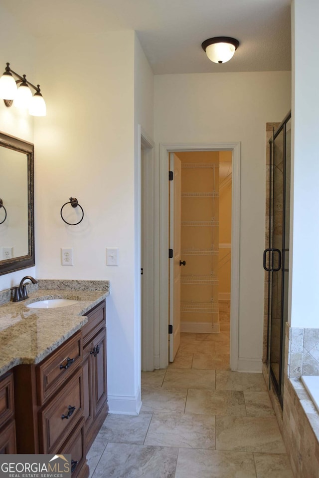 303 Norfolk Cir, Warner Robins, GA 31088 - bathroom featuring vanity, a shower stall, a garden tub, and a spacious closet