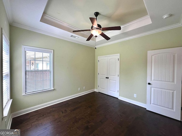 303 Norfolk Cir, Warner Robins, GA 31088 - unfurnished bedroom featuring a raised ceiling, ornamental molding, dark wood-style floors, and a closet