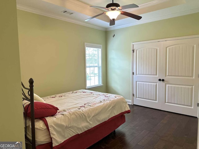 303 Norfolk Cir, Warner Robins, GA 31088 - bedroom featuring crown molding, dark wood-style flooring, a ceiling fan, a raised ceiling, and a closet
